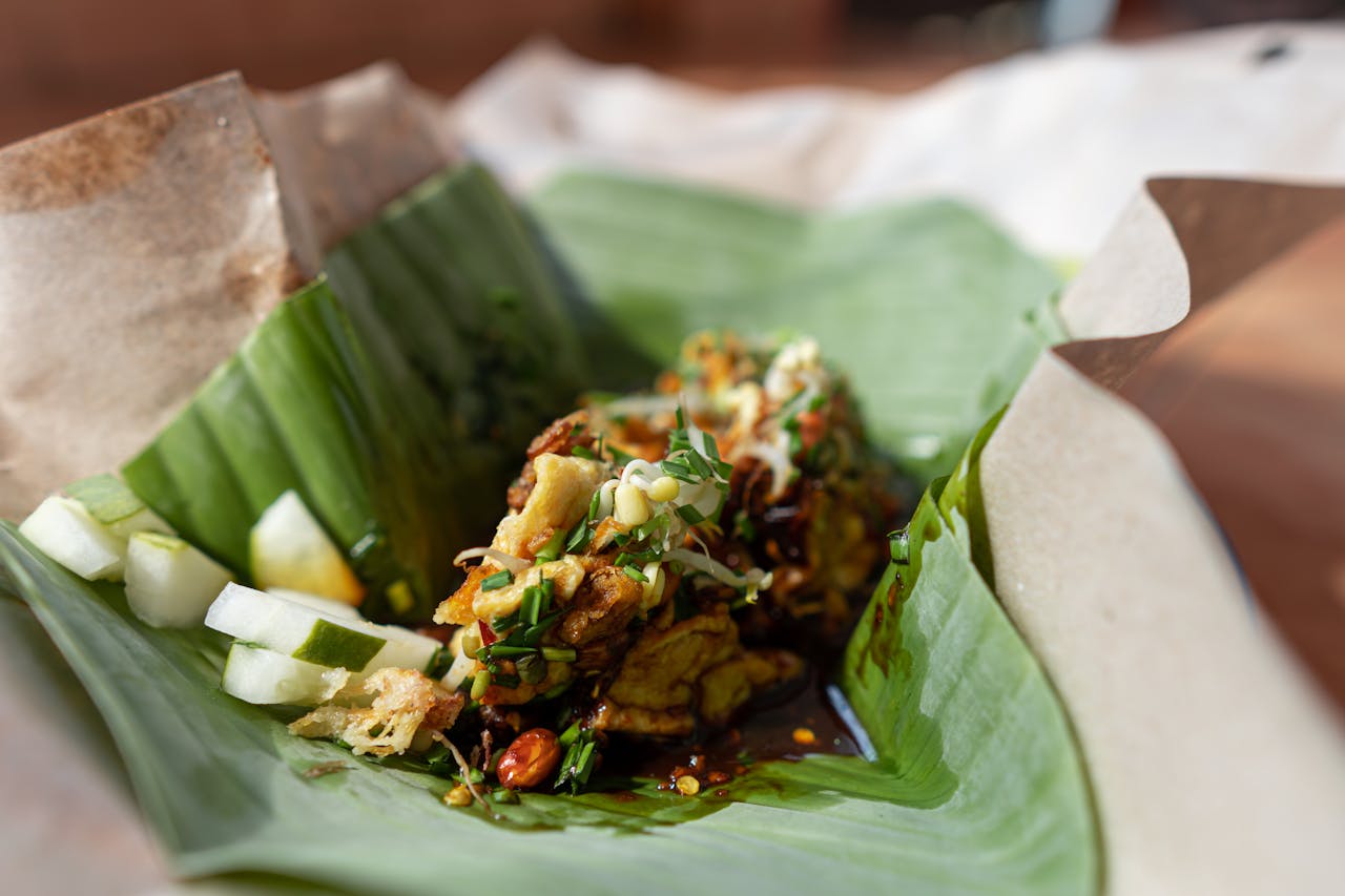 Delicious Indonesian nasi pecel with a blend of vegetables and peanut sauce wrapped in banana leaves.
