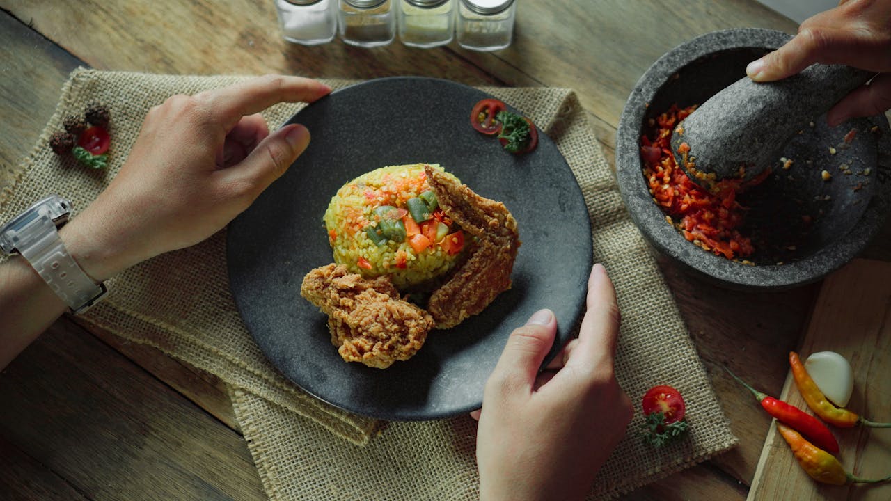 Delicious Indonesian fried chicken served with vibrant nasi goreng in Medan setup.